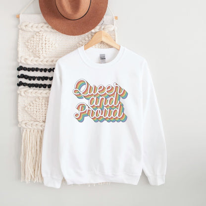 White LGBTQ pride sweatshirt with 'Queer and Proud' rainbow  text on a hanger against a white background