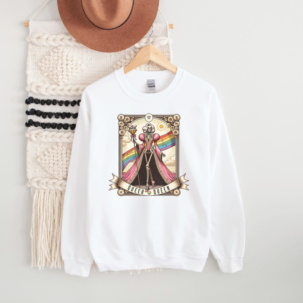 White queer sweatshirt with graphic design on a hanger against a white background