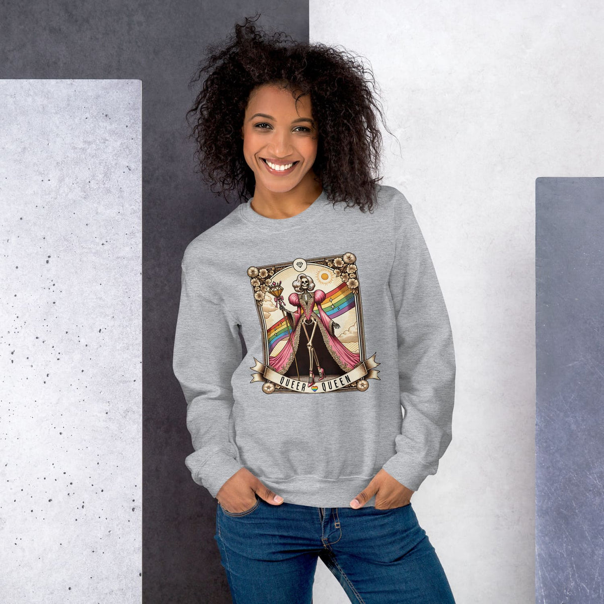 Woman wearing a gray queer sweatshirt with a colorful graphic design against a gray and white background