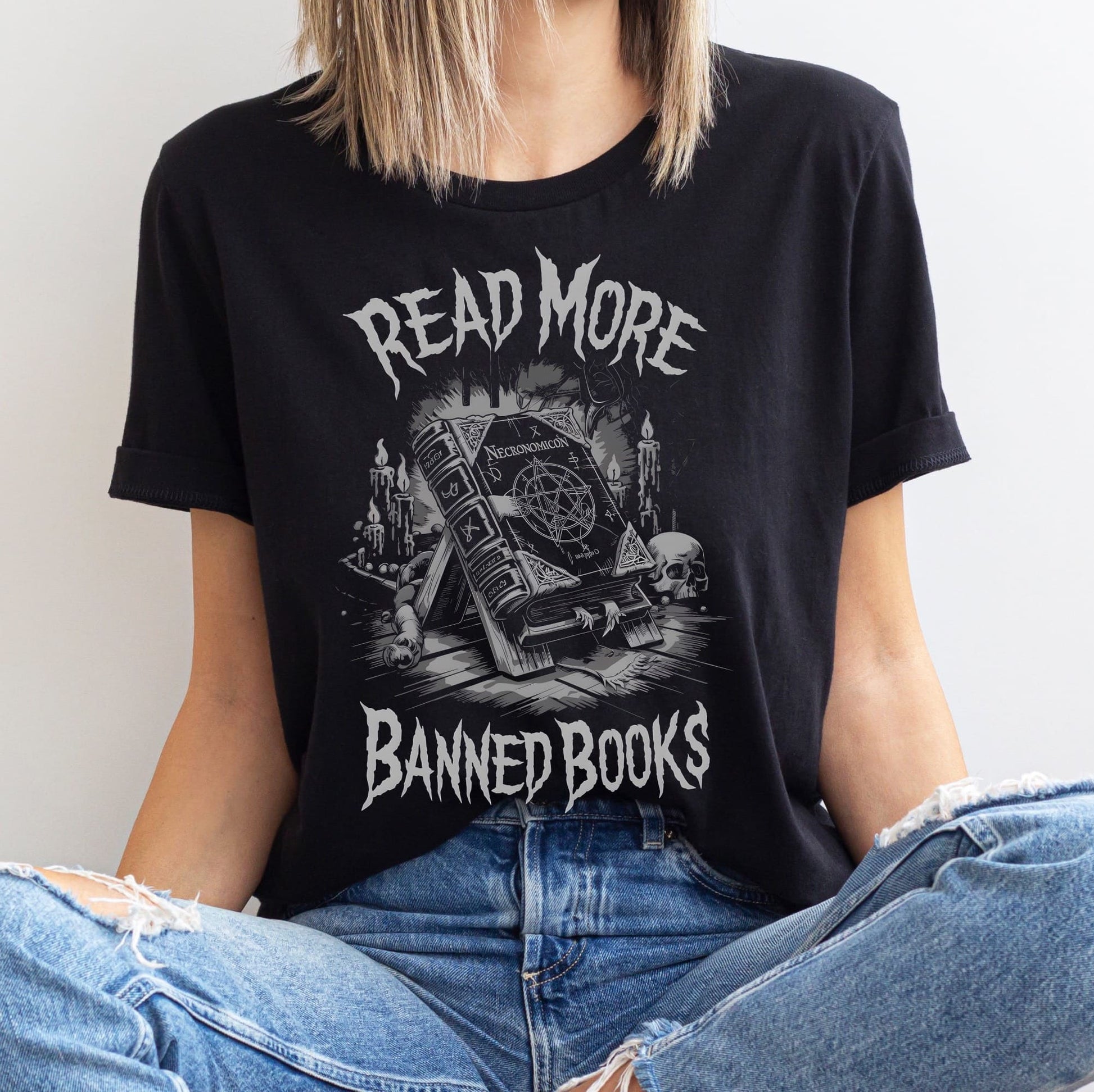 Person wearing a black t-shirt with 'Read More Banned Books' Necronomicon graphic design.
