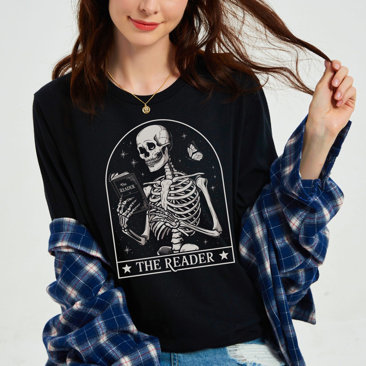 Person wearing a black sweatshirt with a skeleton design and 'The Reader' text.