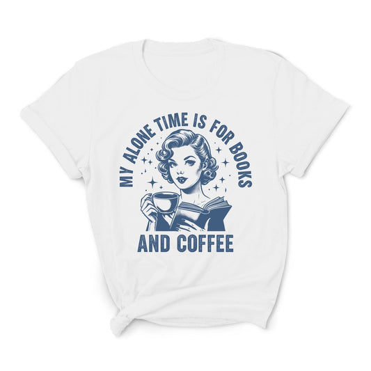 White t-shirt with a graphic of a woman reading a book and holding a coffee cup, with text 'My alone time is for books and coffee' on a white background.