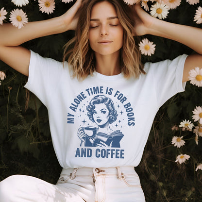 Woman wearing a white bookish t-shirt with a graphic and text, lying in a field of flowers.