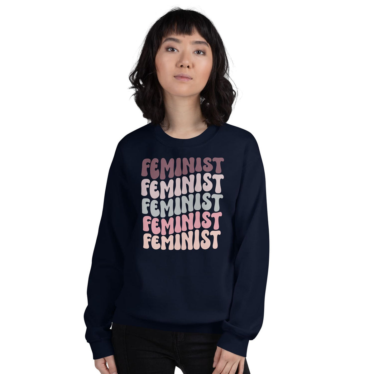 Person wearing a navy blue sweatshirt with 'FEMINIST' text in various colors on a white background