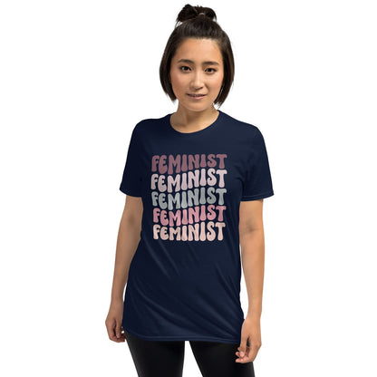Person wearing a navy blue t-shirt with 'FEMINIST' printed in pink multiple times on a white background