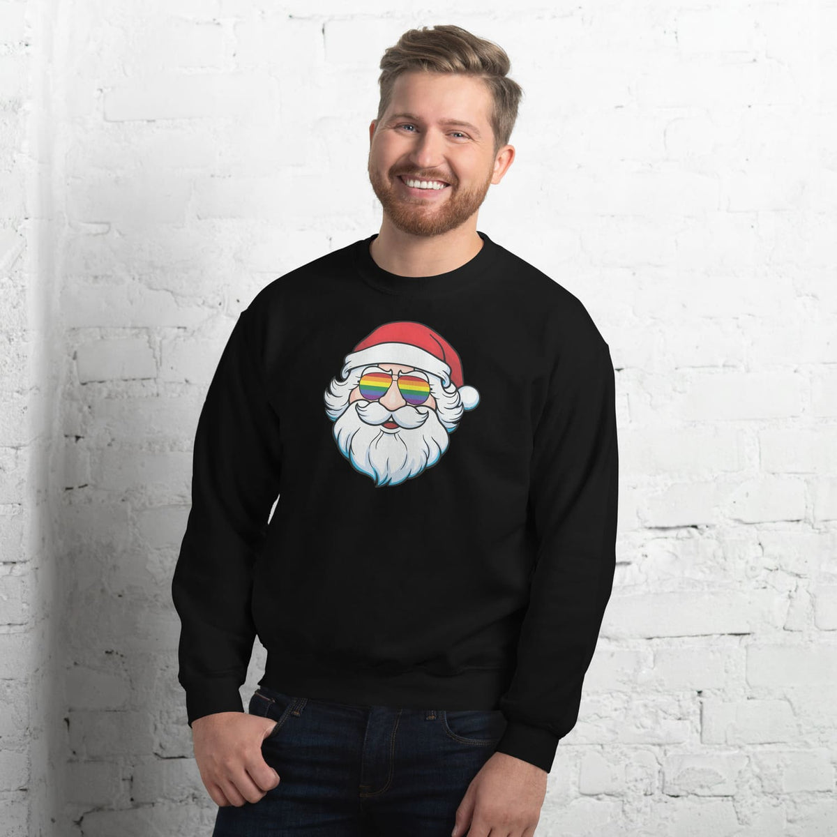 Man wearing a black sweatshirt with a pride Santa Claus design featuring rainbow lgbtq glasses against a white brick wall.
