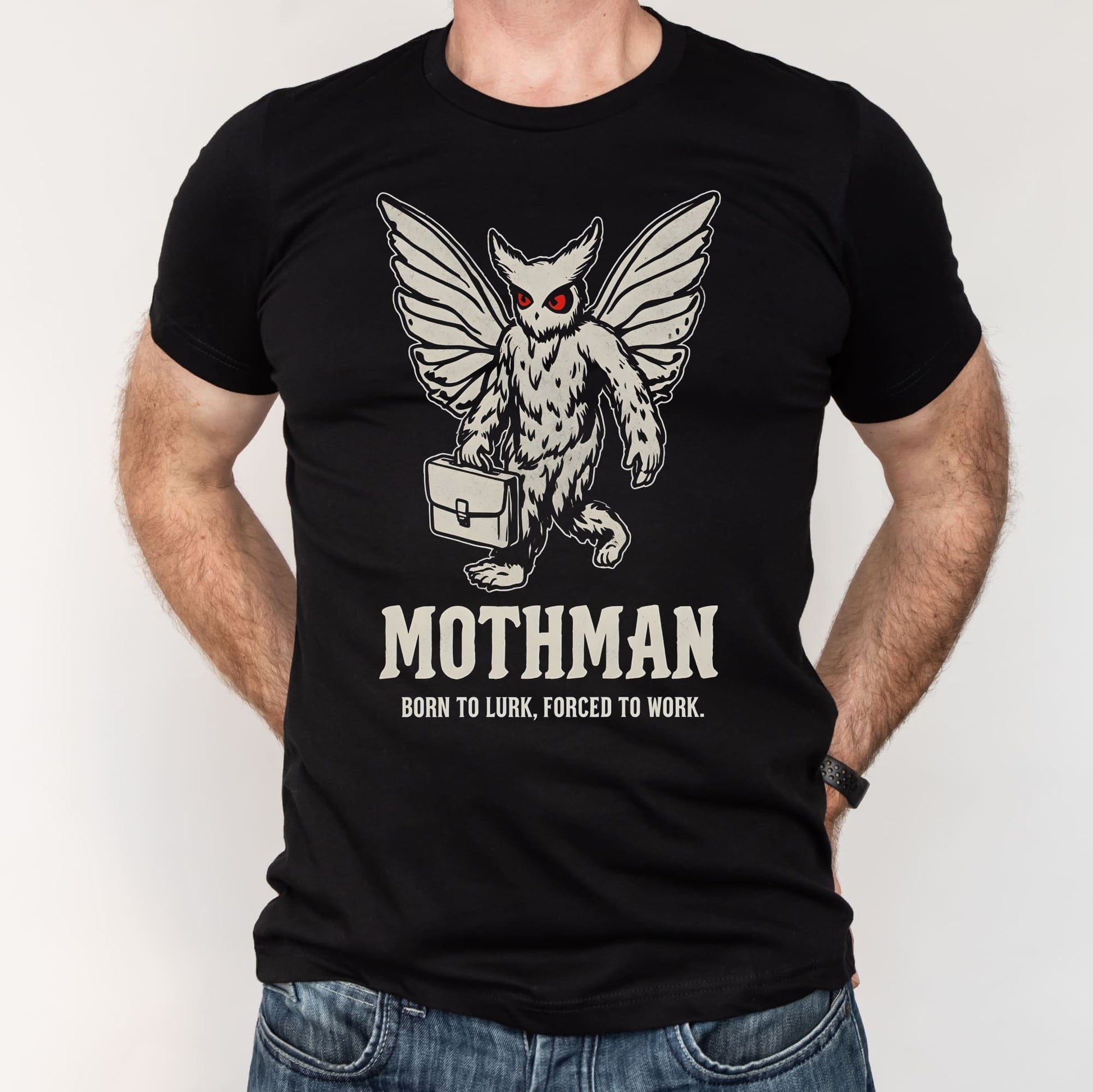 Black t-shirt with Mothman graphic and text worn by a person on a white background