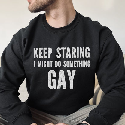 Person wearing a black sweatshirt with text 'KEEP STARING I MIGHT DO SOMETHING GAY' on a neutral background