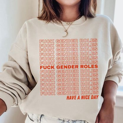 enby Person wearing a beige sweatshirt with red text stating 'FUCK GENDER ROLES' repeated multiple times, followed by 'HAVE A NICE DAY'.