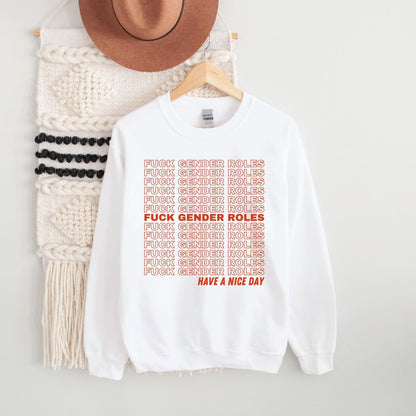 White non cisgender sweatshirt with red text on a hanger next to a knitted item and hat.