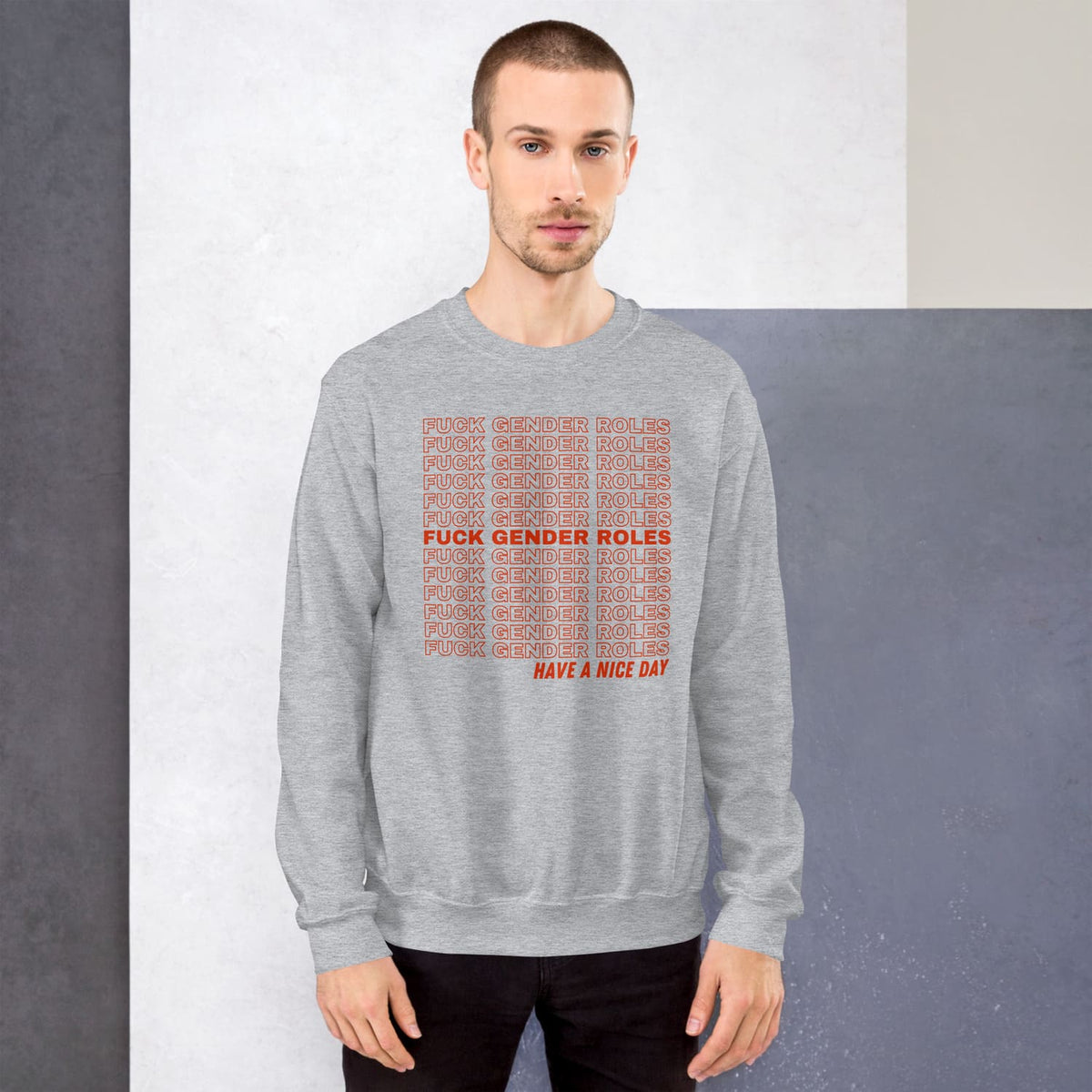 enby Person wearing a gray nonbinary sweatshirt with red text on a plain background