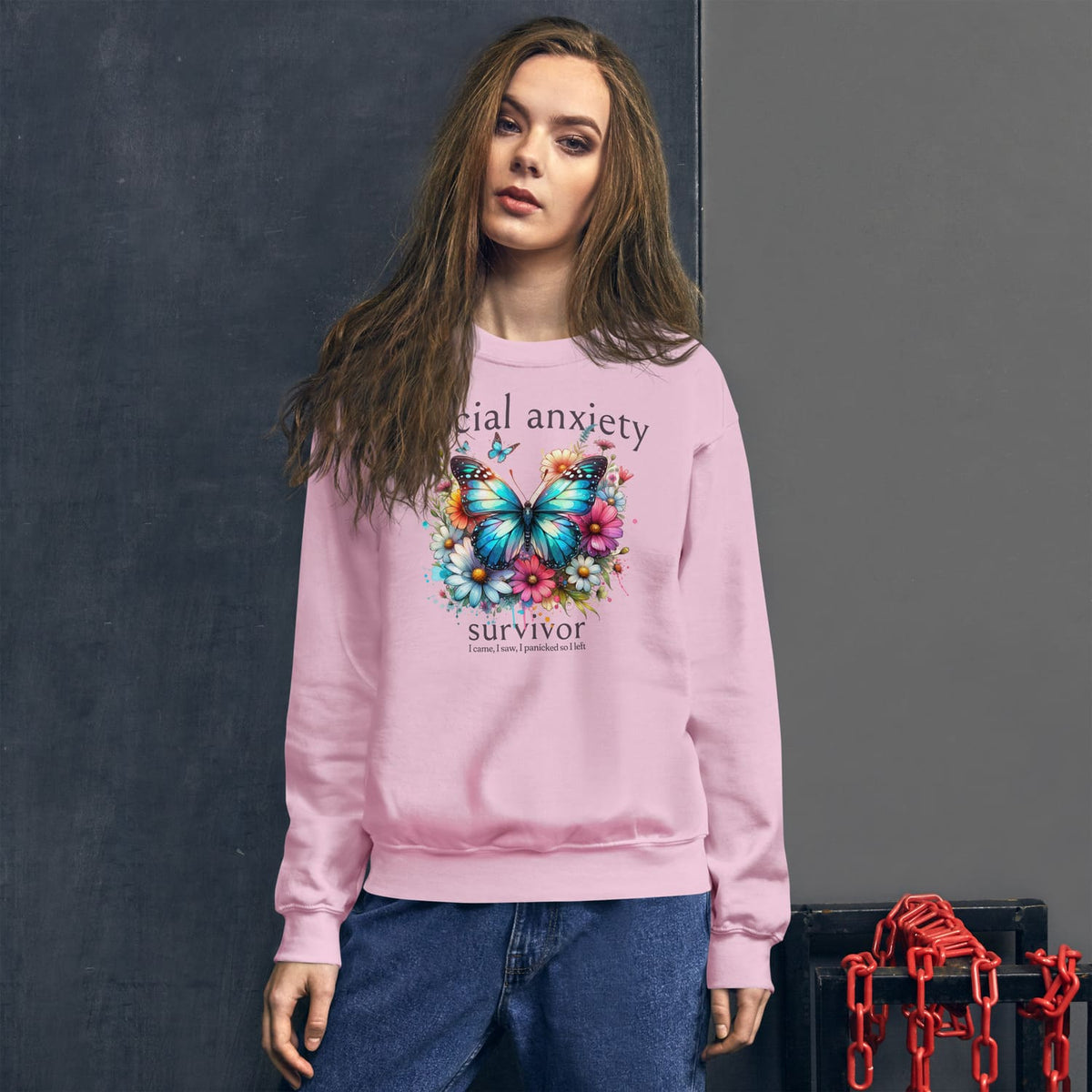 Person wearing a pink social anxiety sweatshirt with a butterfly design and text on a dark background