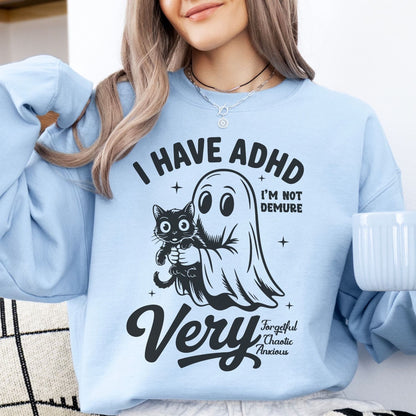 Person wearing a light blue spooky ADHD sweatshirt with a graphic and text, holding a mug