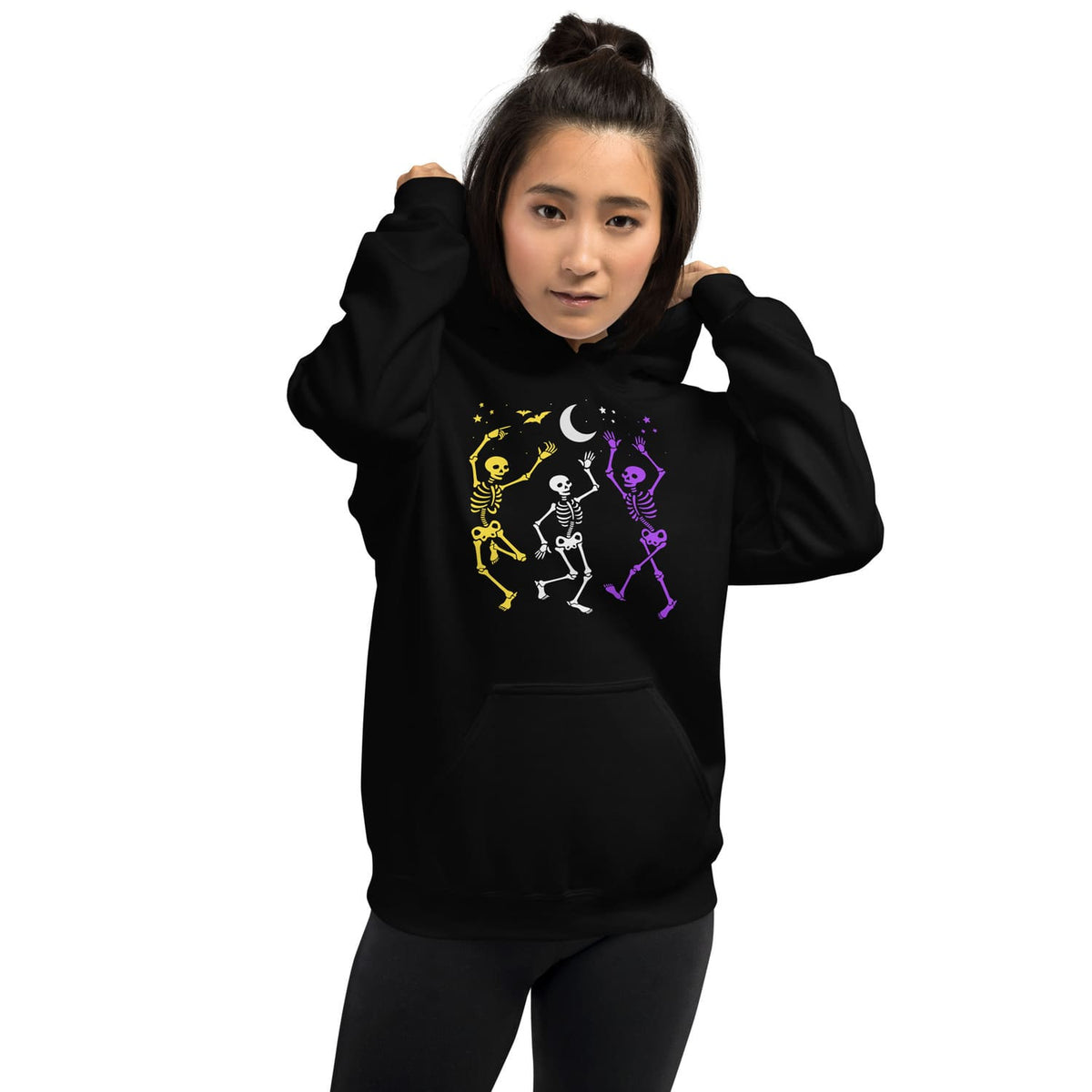 Person wearing a black hoodie with nonbinary dancung skeletons text on a white background