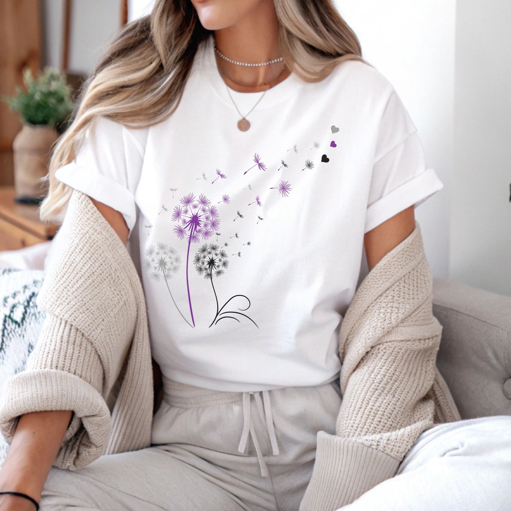 Person wearing a white t-shirt with floral design sitting on a couch.