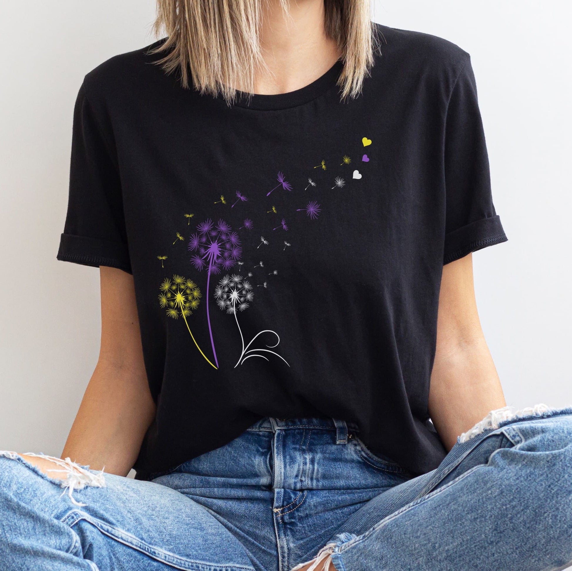 Person wearing a black t-shirt with colorful floral design against a white background