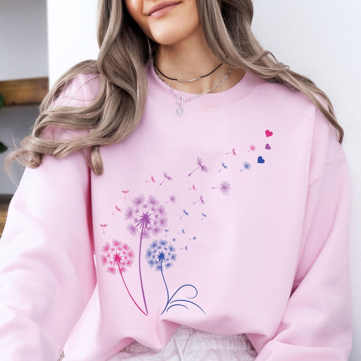 Person wearing a pink bisexual sweatshirt with floral designs