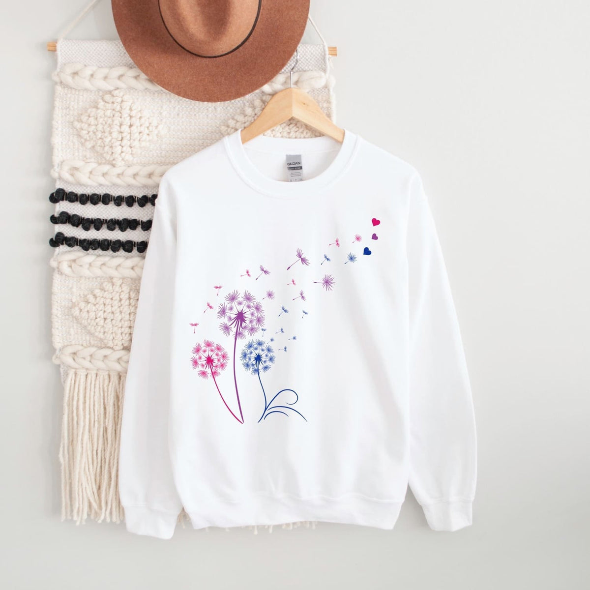 White bisexual sweatshirt with floral design on a hanger against a white background