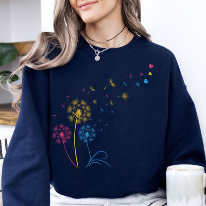 Person wearing a navy blue pansexual sweatshirt with colorful dandelion designs.