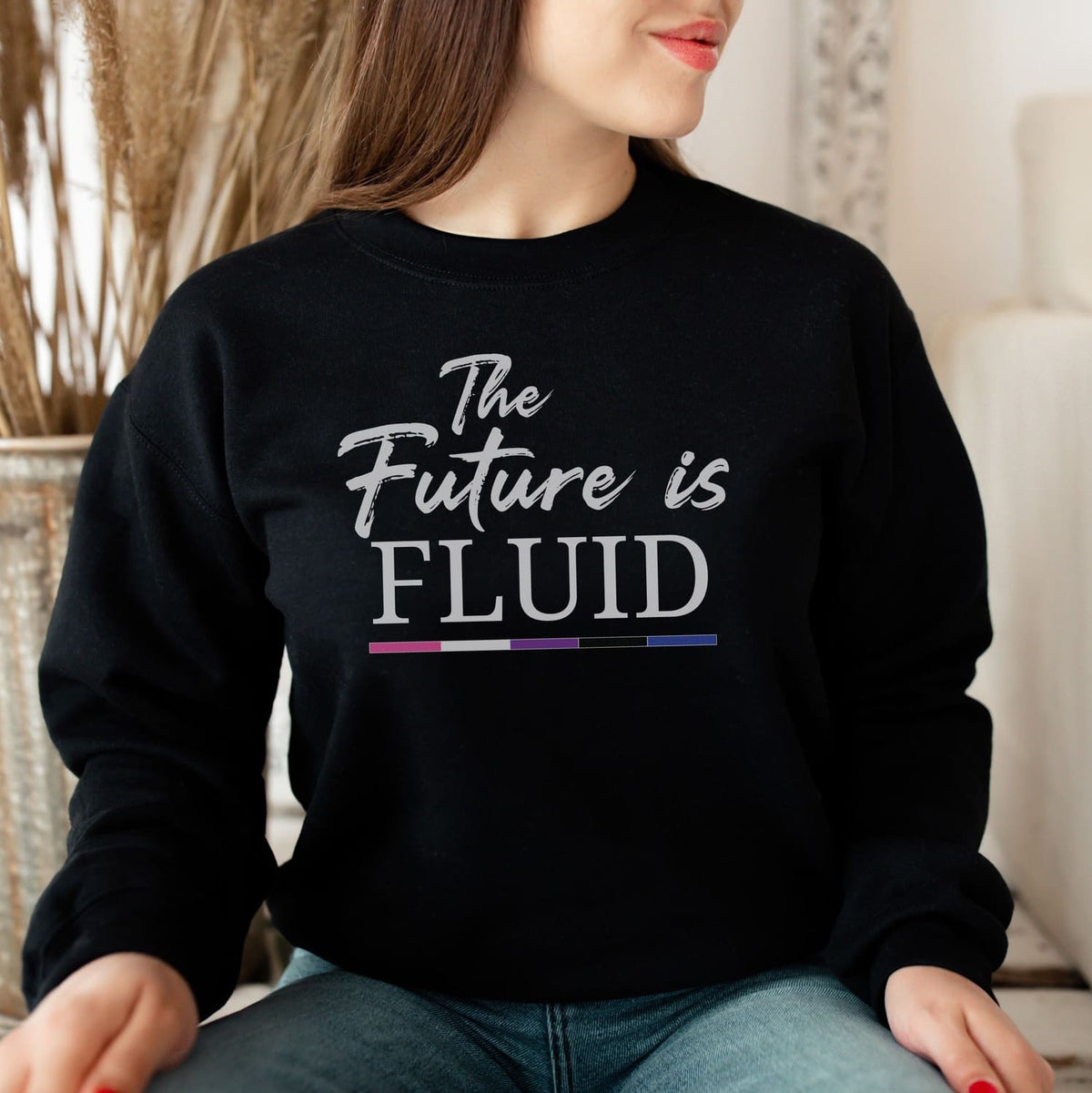 genderfluid person wearing a black sweatshirt with 'The Future is Fluid' text.