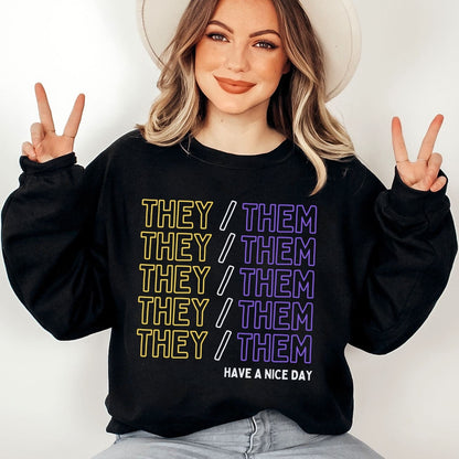 Enby Person wearing a black sweatshirt with 'THEY/ THEM' pronouns text and making peace signs.