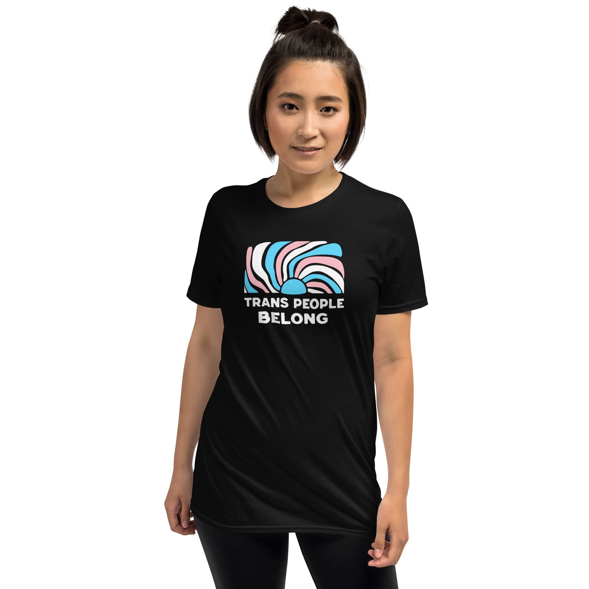 Person wearing a black t-shirt with 'Trans People Belong' text and abstract design on a white background