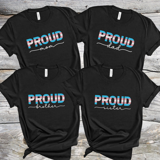 Transgender alies t-shirts with 'PROUD MOM, DAD, SISTER and BROTHER' text in different family roles on a wooden surface.
