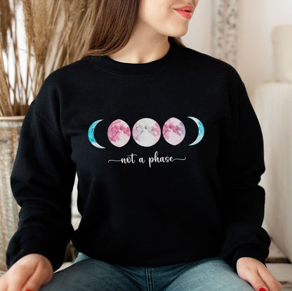MTF transgender  wearing a black sweatshirt with a moon phase design and text 'not a phase'