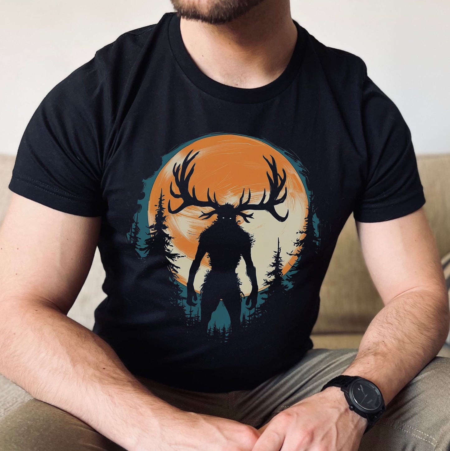 Person wearing a black t-shirt with a graphic of wendigo silhouette against an orange sky.