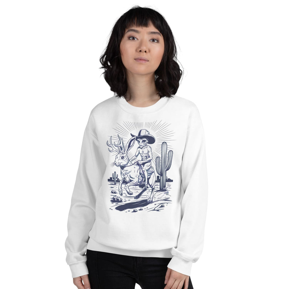 Person wearing a white western sweatshirt with a jackalope and alien graphic design on a white background