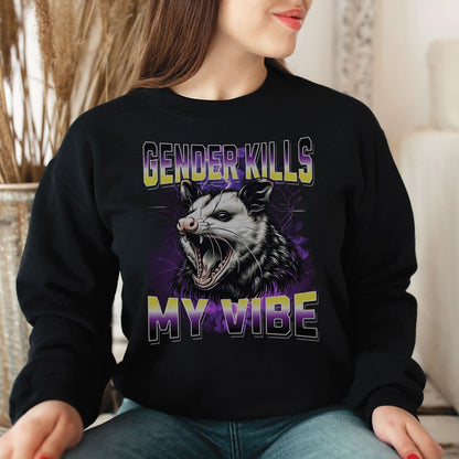 Nonbinary person wearing a black sweatshirt with an opossum graphic and text 'Gender Kills My Vibe' in a home setting.